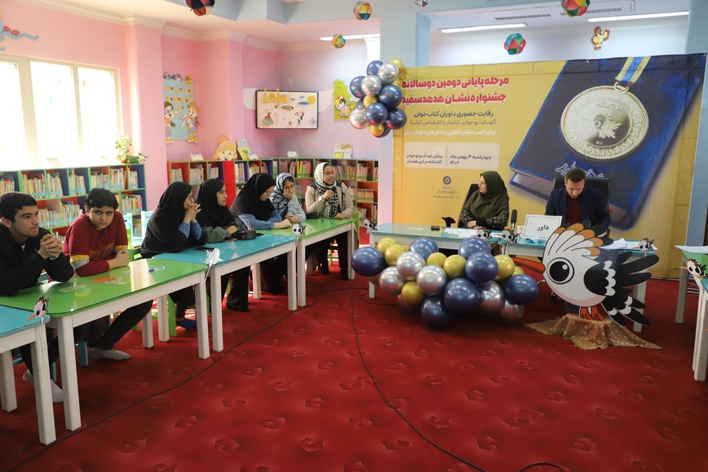 نشان نقرهای هدهد سفید بر گردن ۱۴ کتابخوان همدانی