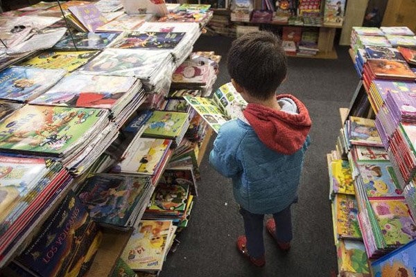 نگاه‌های حسرت‌بار کودکان به کتاب‌های گران در یک نمایشگاه استانی